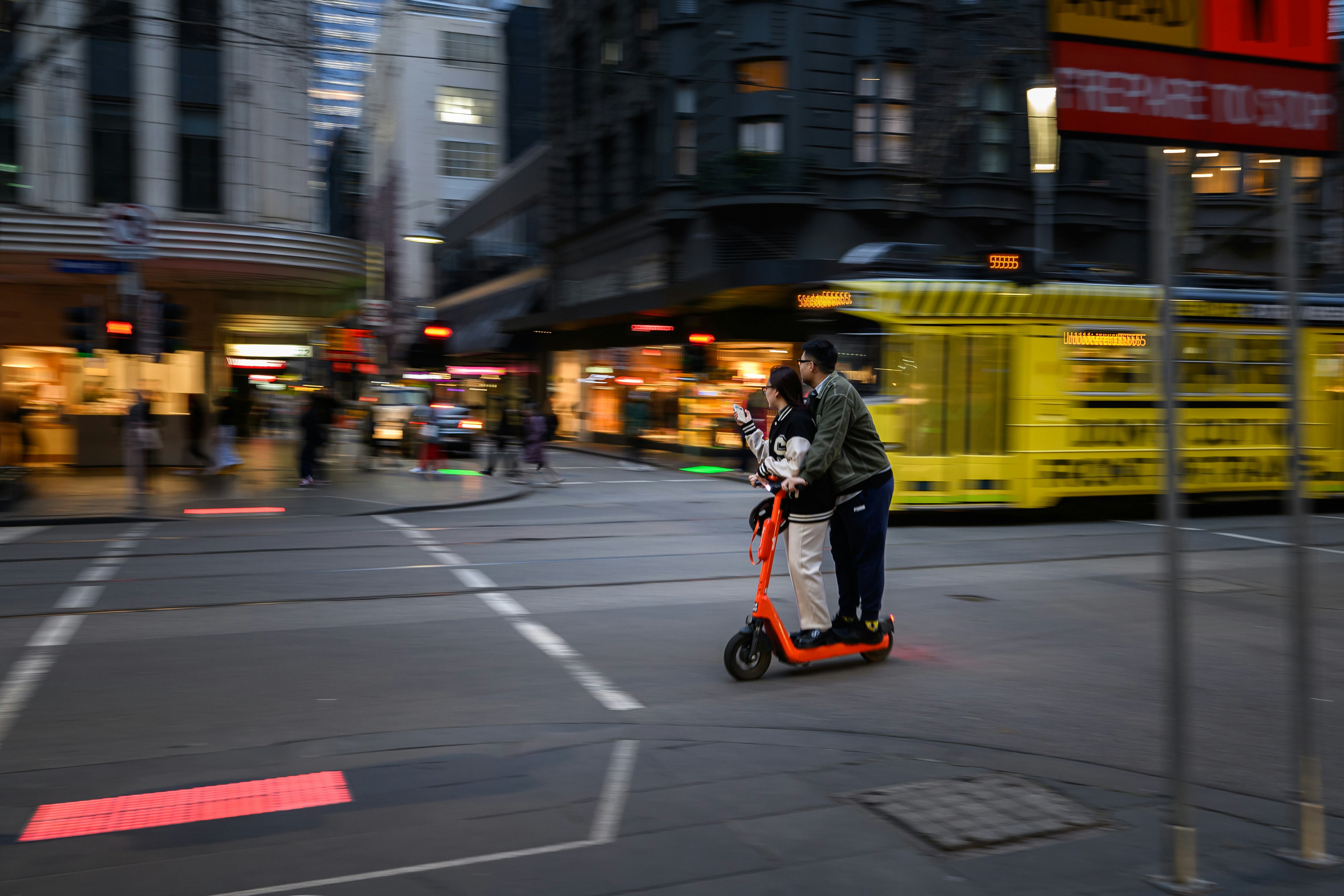 Couple riding a scooter in the city of Melbourne