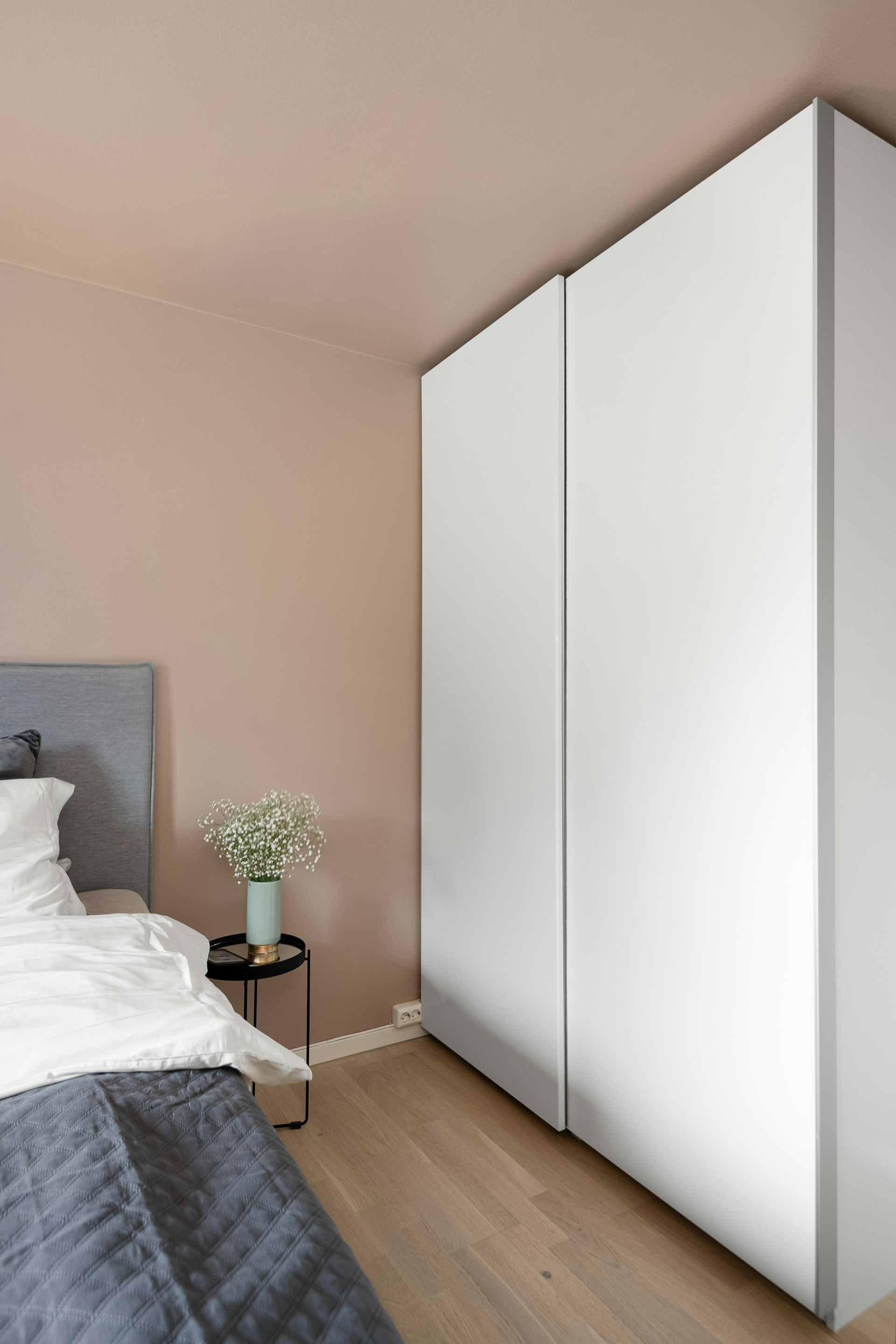 A bedroom with a bed and a white cabinet