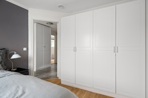 A bedroom with a bed and white cabinets