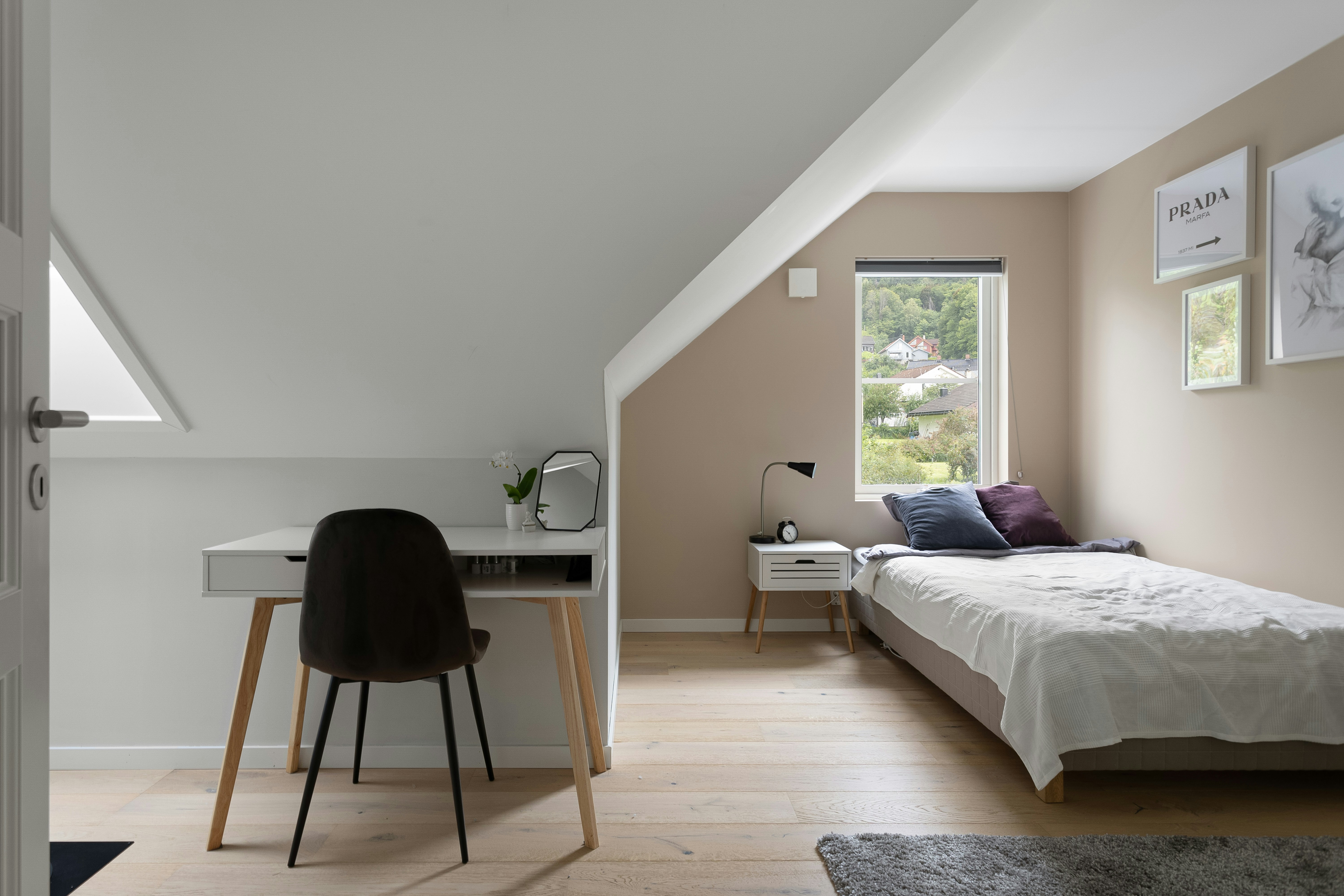 A bedroom with a bed, desk, and chair in it