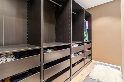 A walk in closet filled with lots of shoes
