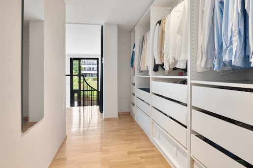 A walk in closet filled with lots of clothes