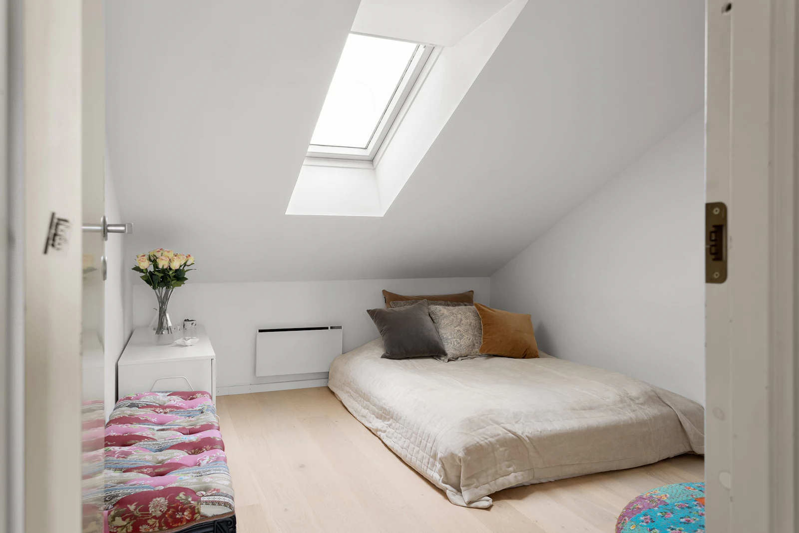 Loft conversion bedroom with a large roof window and oak floor