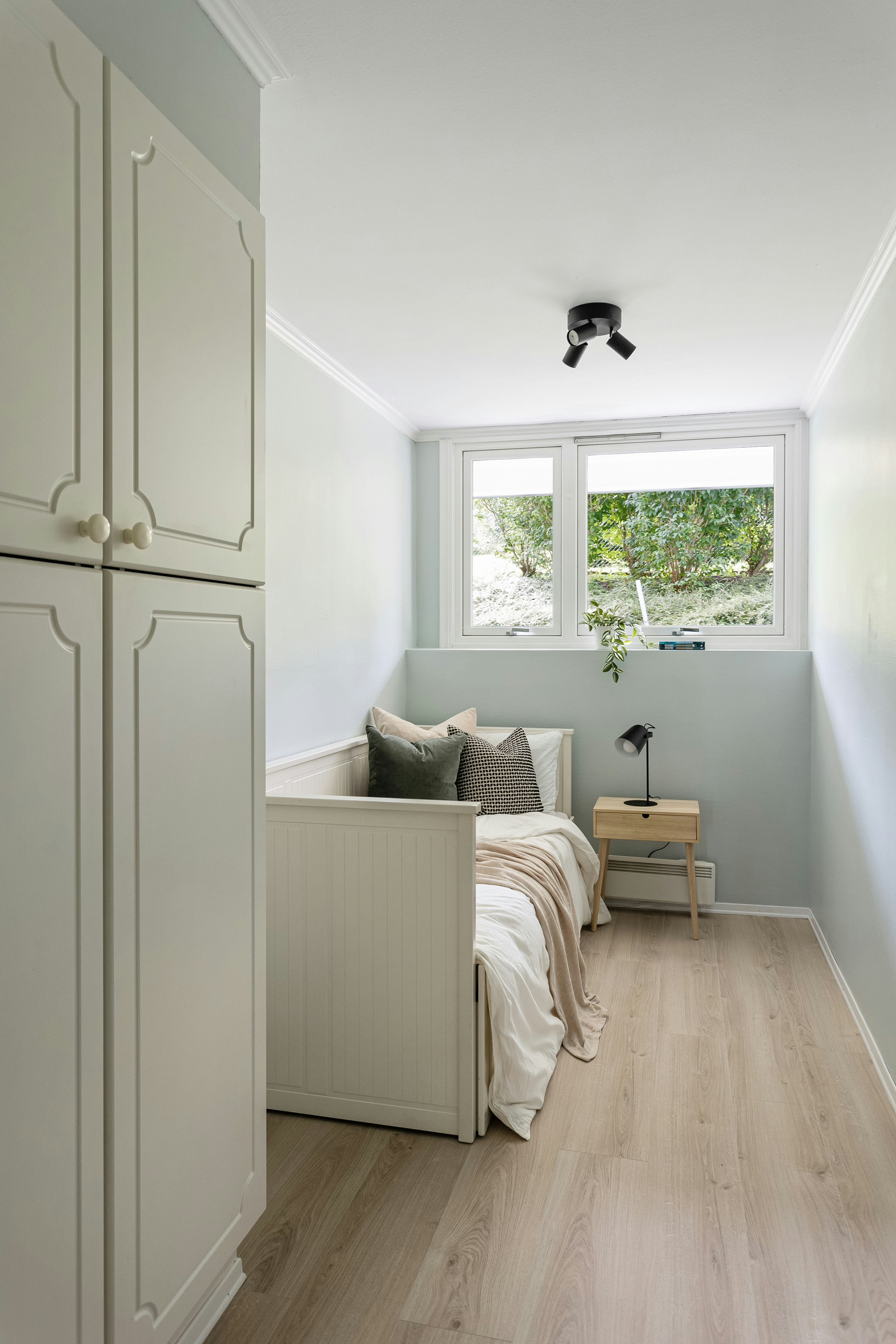 A room with a bed, a couch and a window