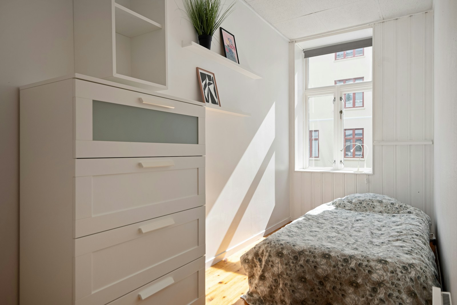 small pre-war bedroom with tall dresser and no closet
