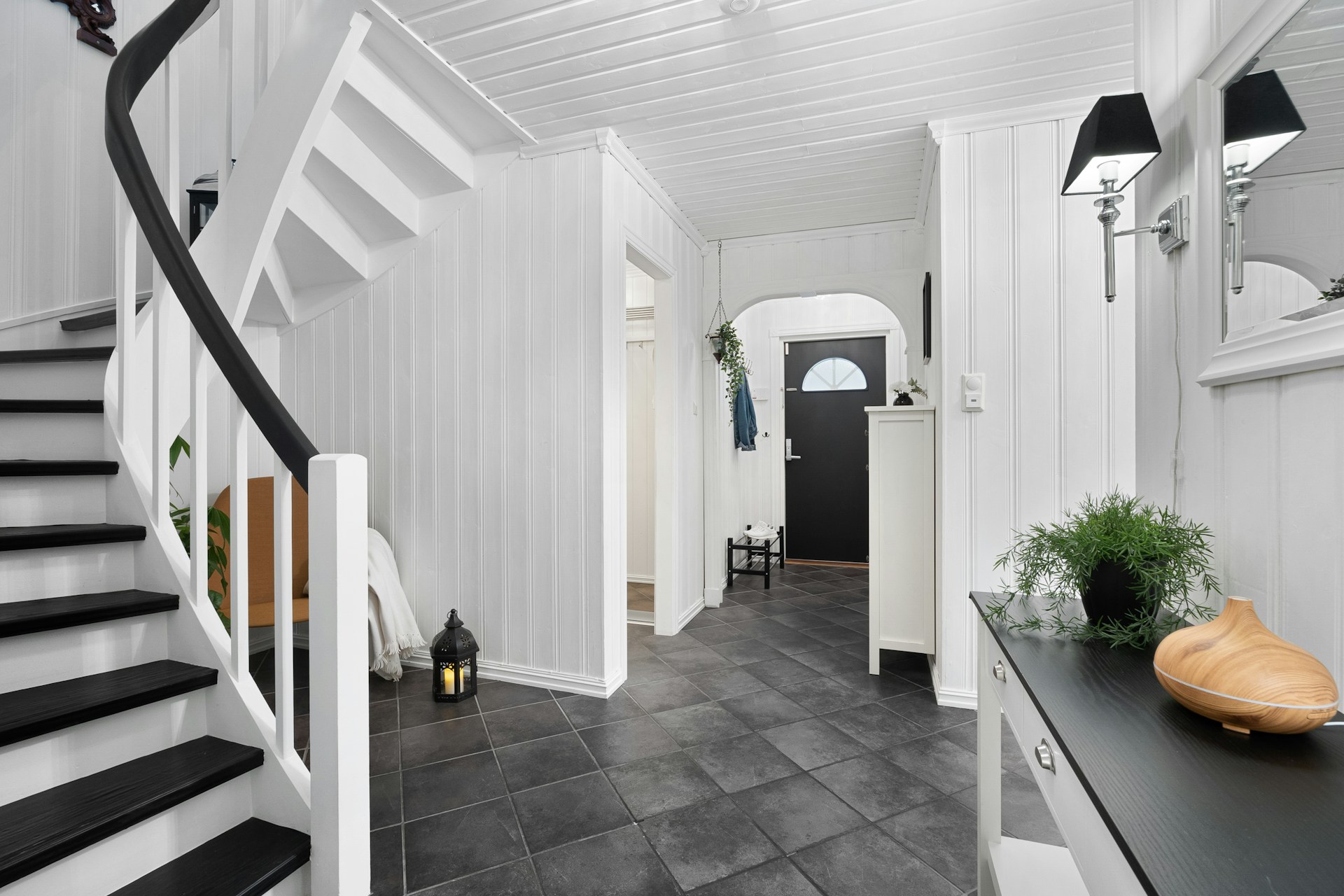 A black and white hallway with a black and white staircase