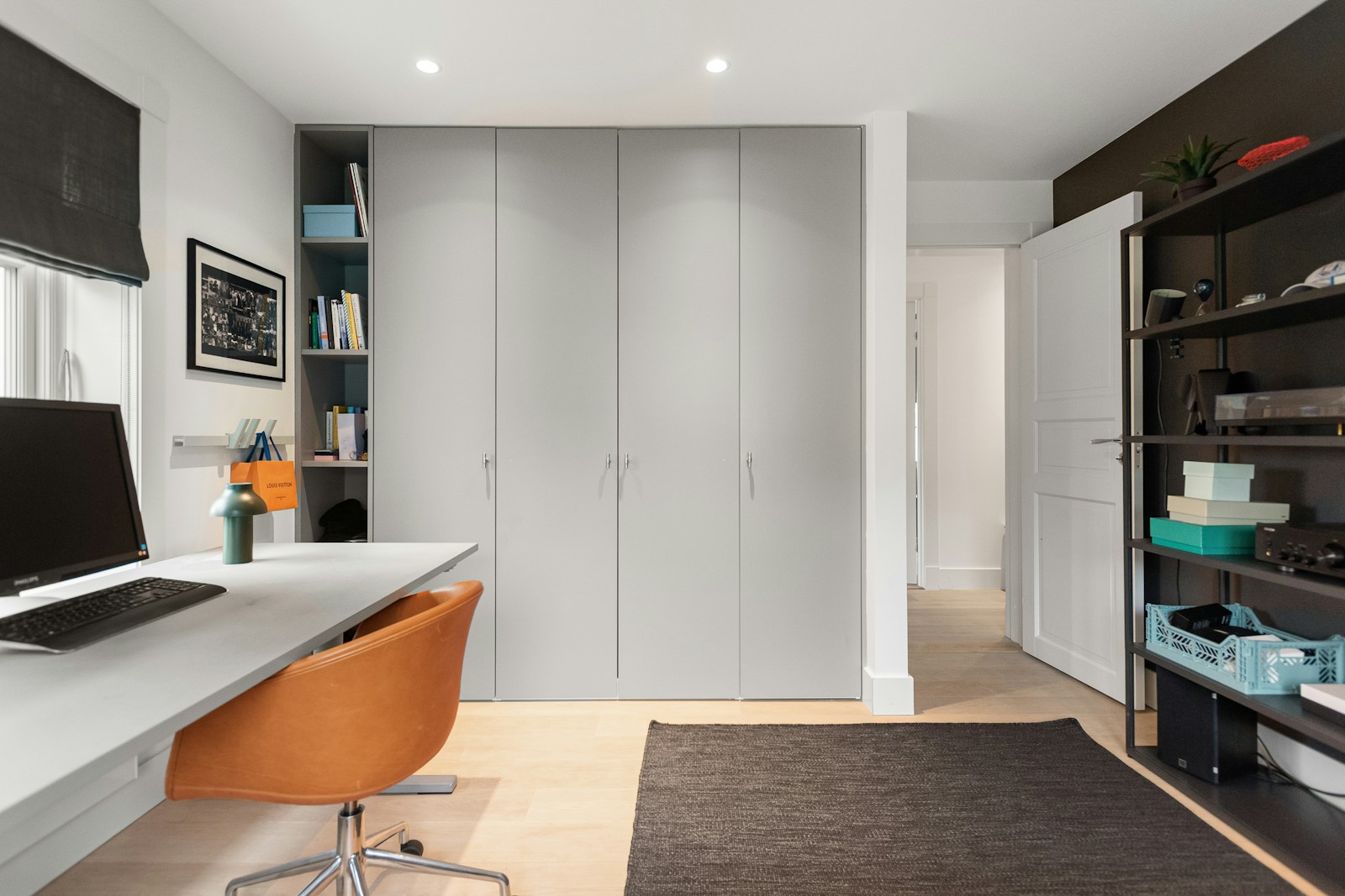 small studio with built-in desk and chair against closet doors