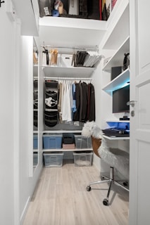 A walk in closet with a desk and shelves