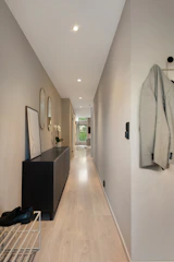 A long hallway with a coat rack and coat hanging on the wall