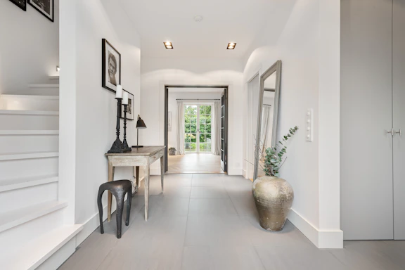 A long hallway with white walls and wooden floors