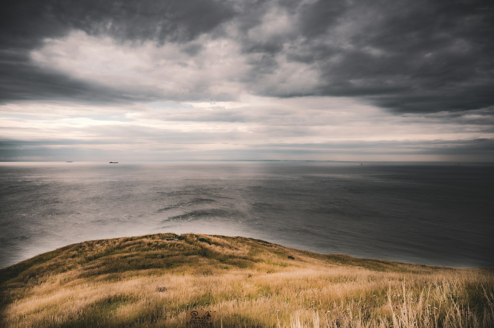 A grassy hill with a body of water in the background