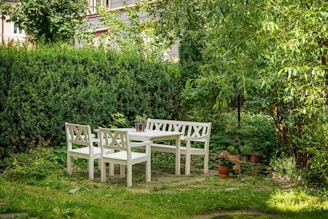 A white table and four chairs in a garden