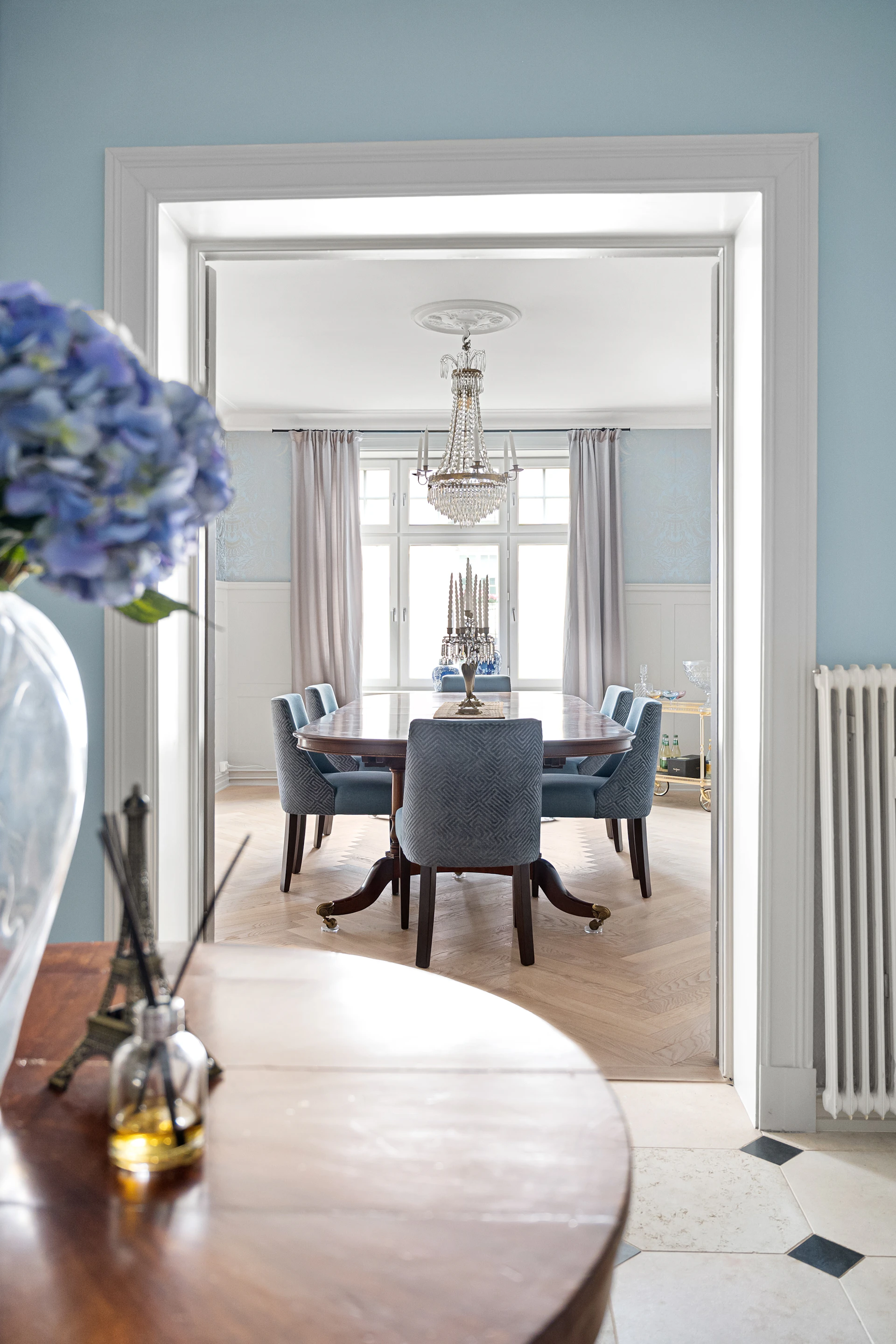 A dining room table with a vase of flowers on it