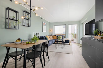A living room and dining room with a television on the wall