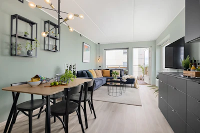 A living room and dining room with a television on the wall