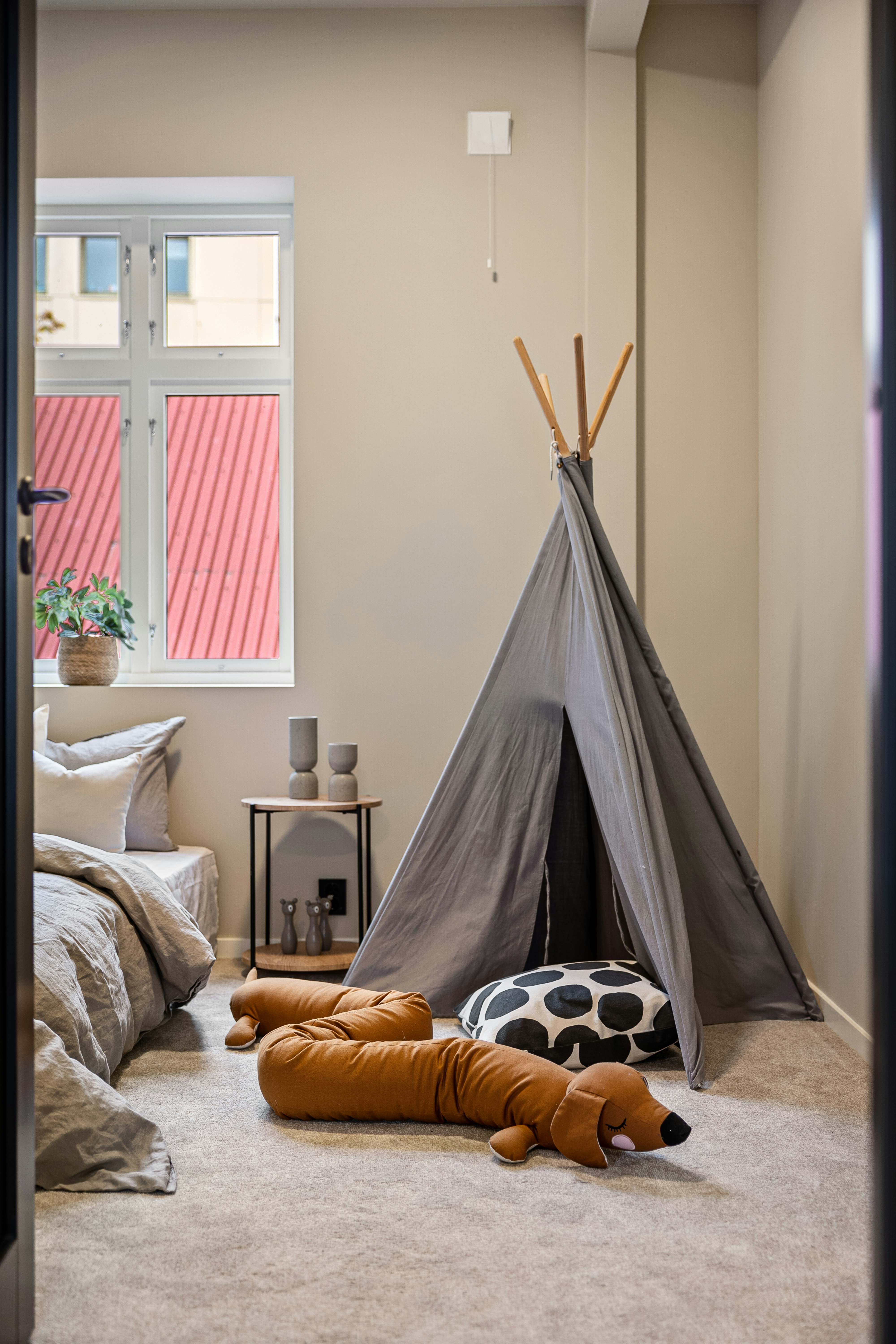 Witte tipi-speeltent in een lichte kinderkamer