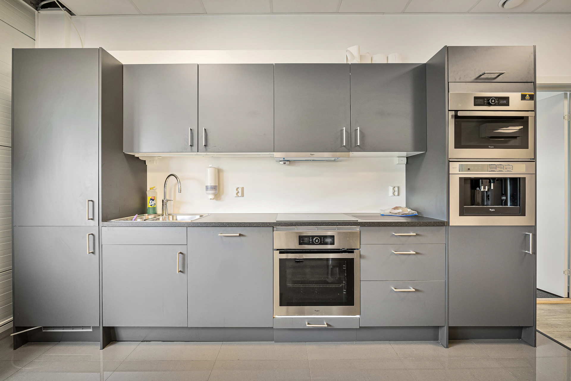 A kitchen with a stove, oven, microwave and cabinets