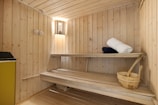 A wooden room with a bench and a sink