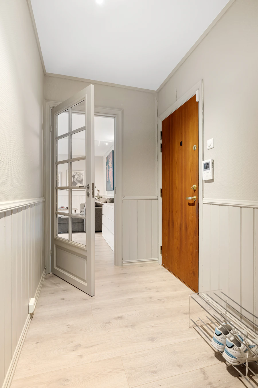 Long white hallway ending in a wood interior door