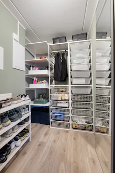 A walk in closet filled with lots of shoes