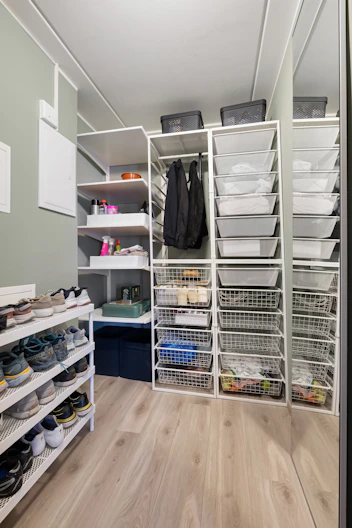 A walk in closet filled with lots of shoes