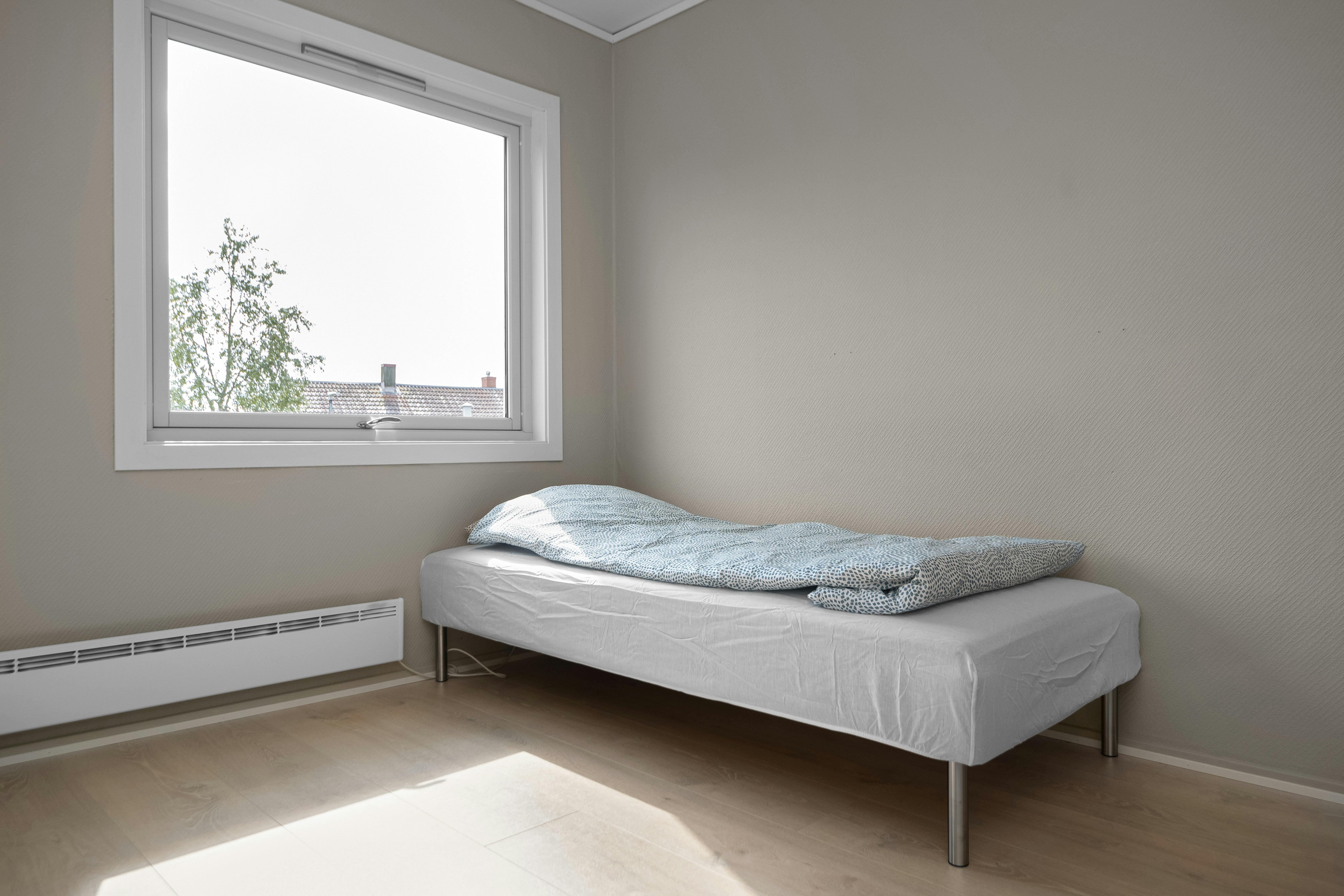 A bed sitting in a bedroom next to a window