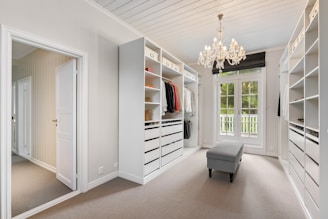 A walk in closet with a chandelier hanging from the ceiling