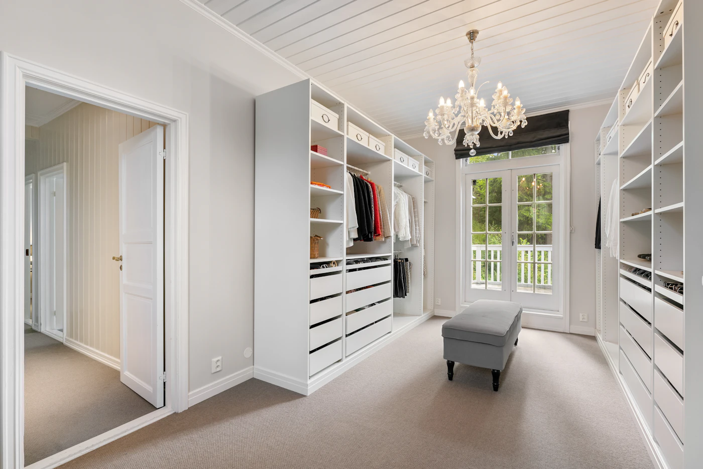 Walk-in closet de lujo con lámpara colgante e isla central