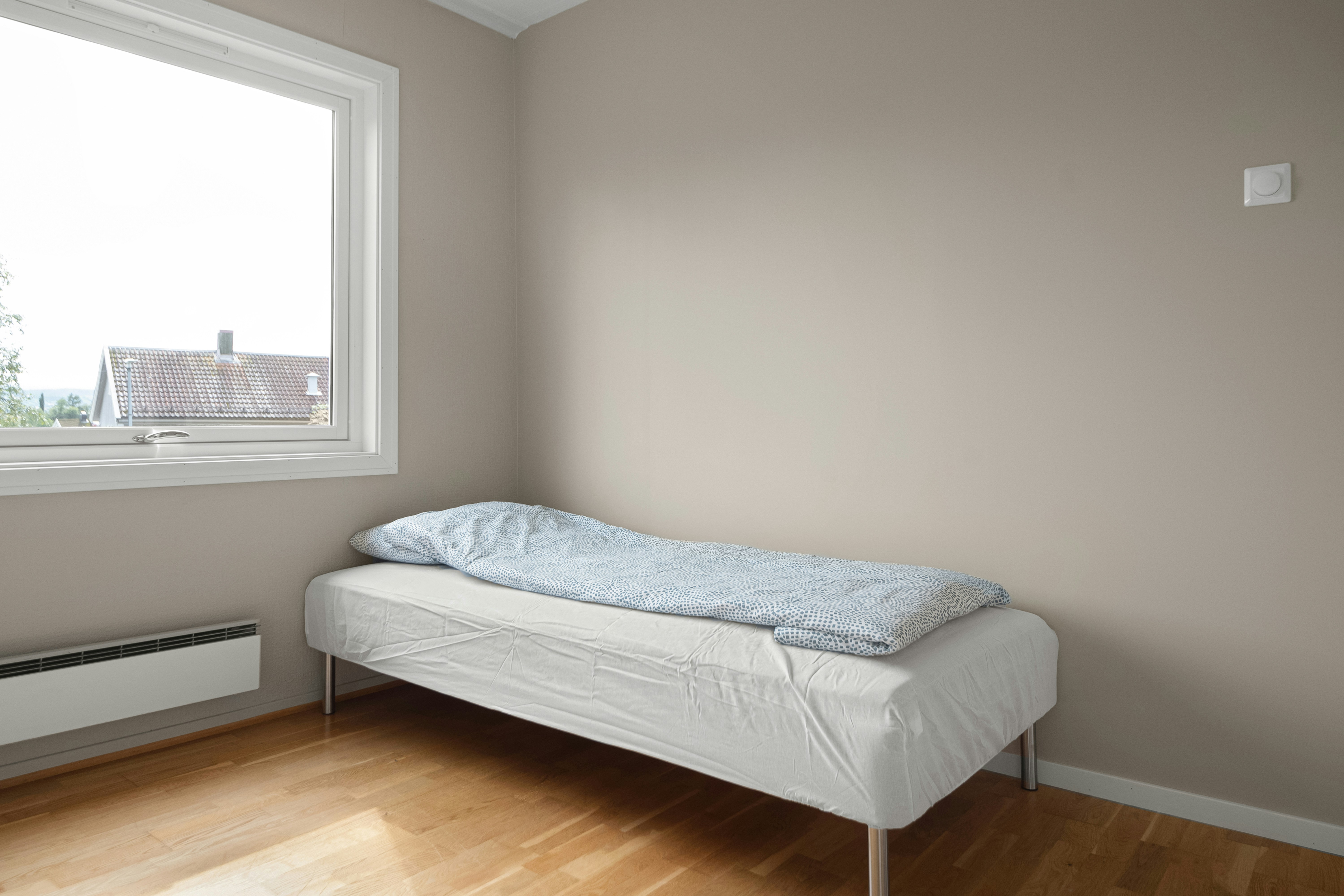 A bed sitting in a bedroom next to a window