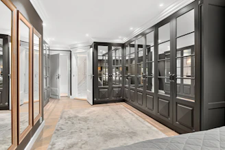 A bedroom with a large bed and a mirrored closet