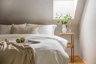 A bed with a white comforter and pillows