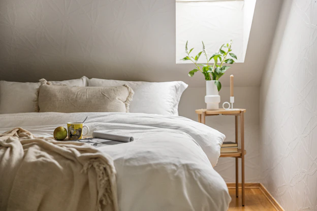 A bed with a white comforter and pillows