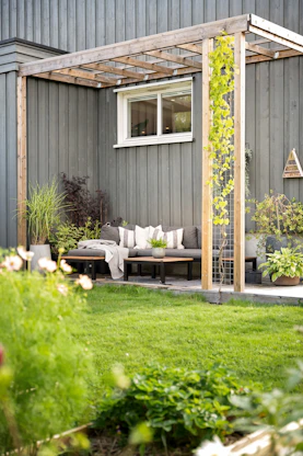 A backyard area with a couch and a pergolan