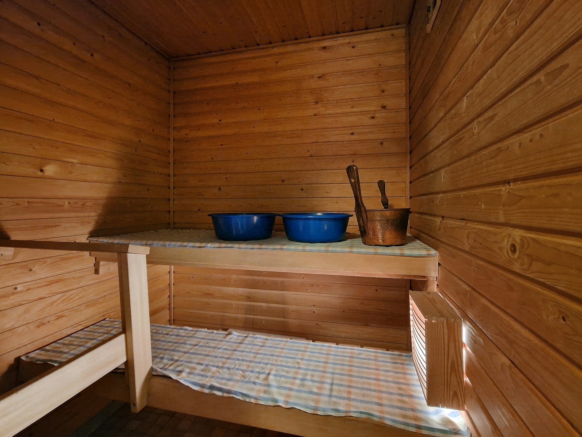 A wooden sauna with two blue bowls on top of it