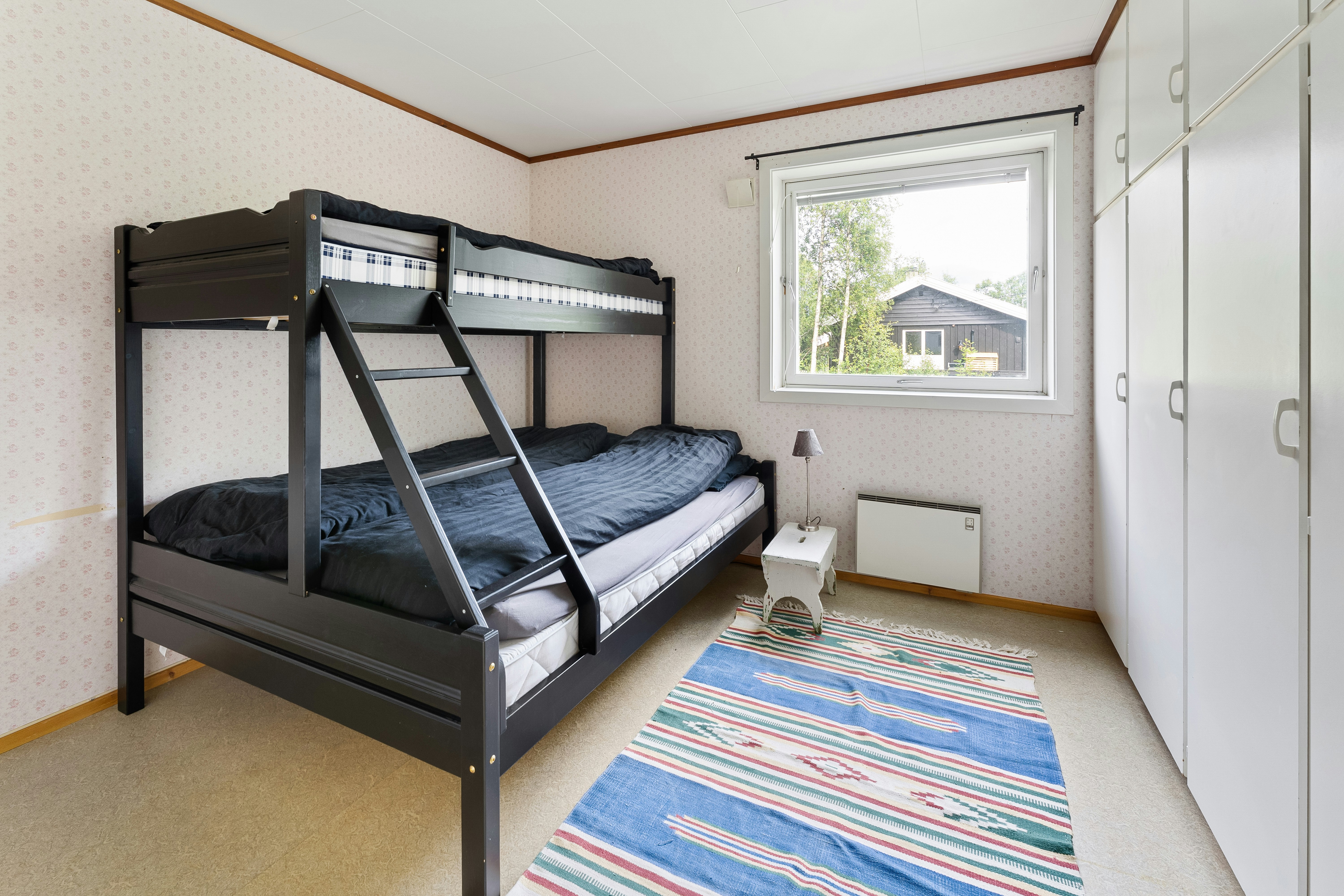 A bedroom with bunk beds and a rug on the floor