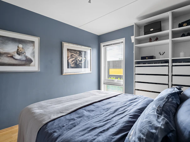 A bedroom with blue walls and a large bed