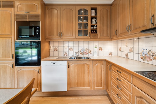 A kitchen with wooden cabinets and a white dishwasher