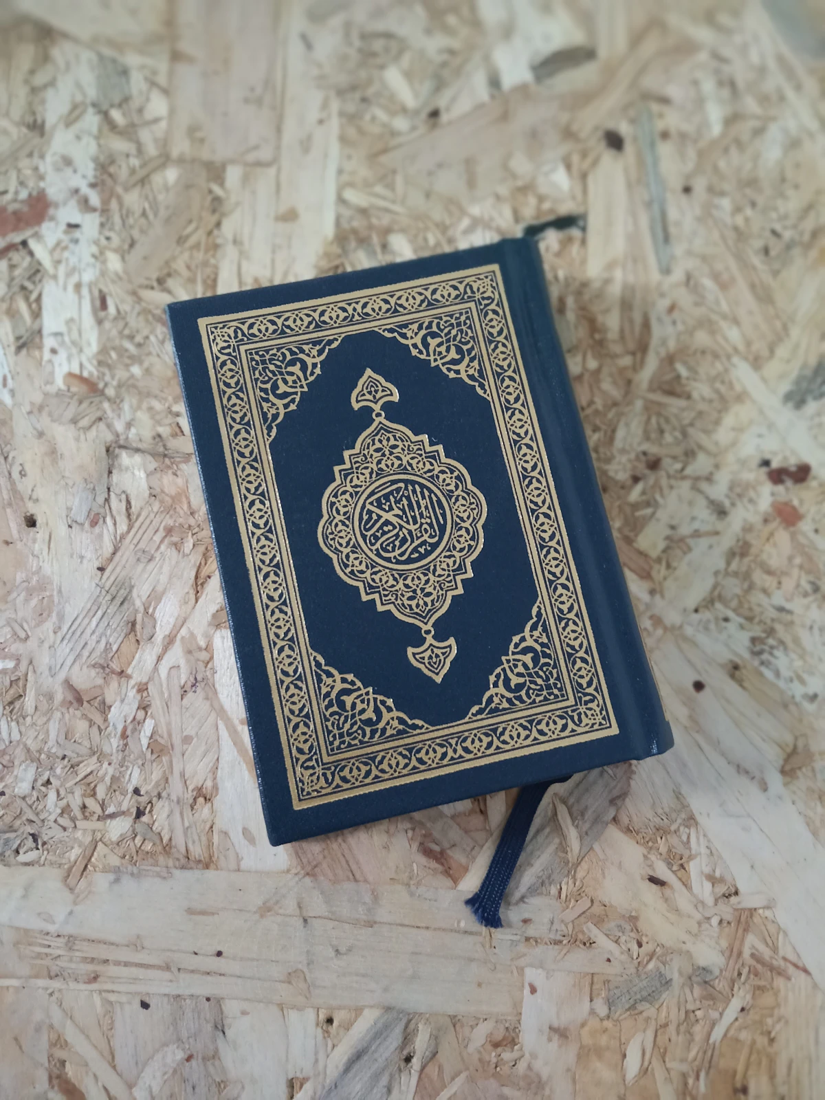 Livre du Coran fermé posé au sol en bois