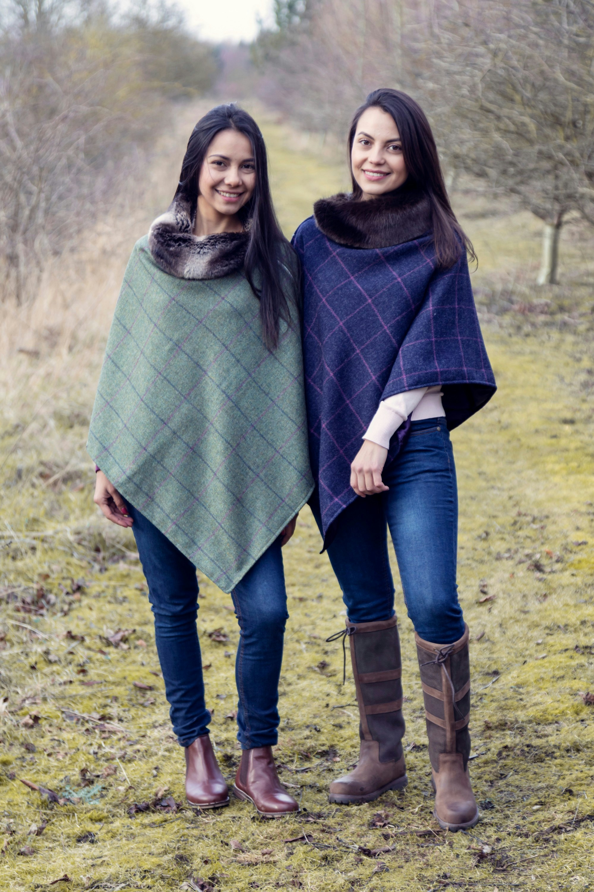 Two women standing next to each other in a field