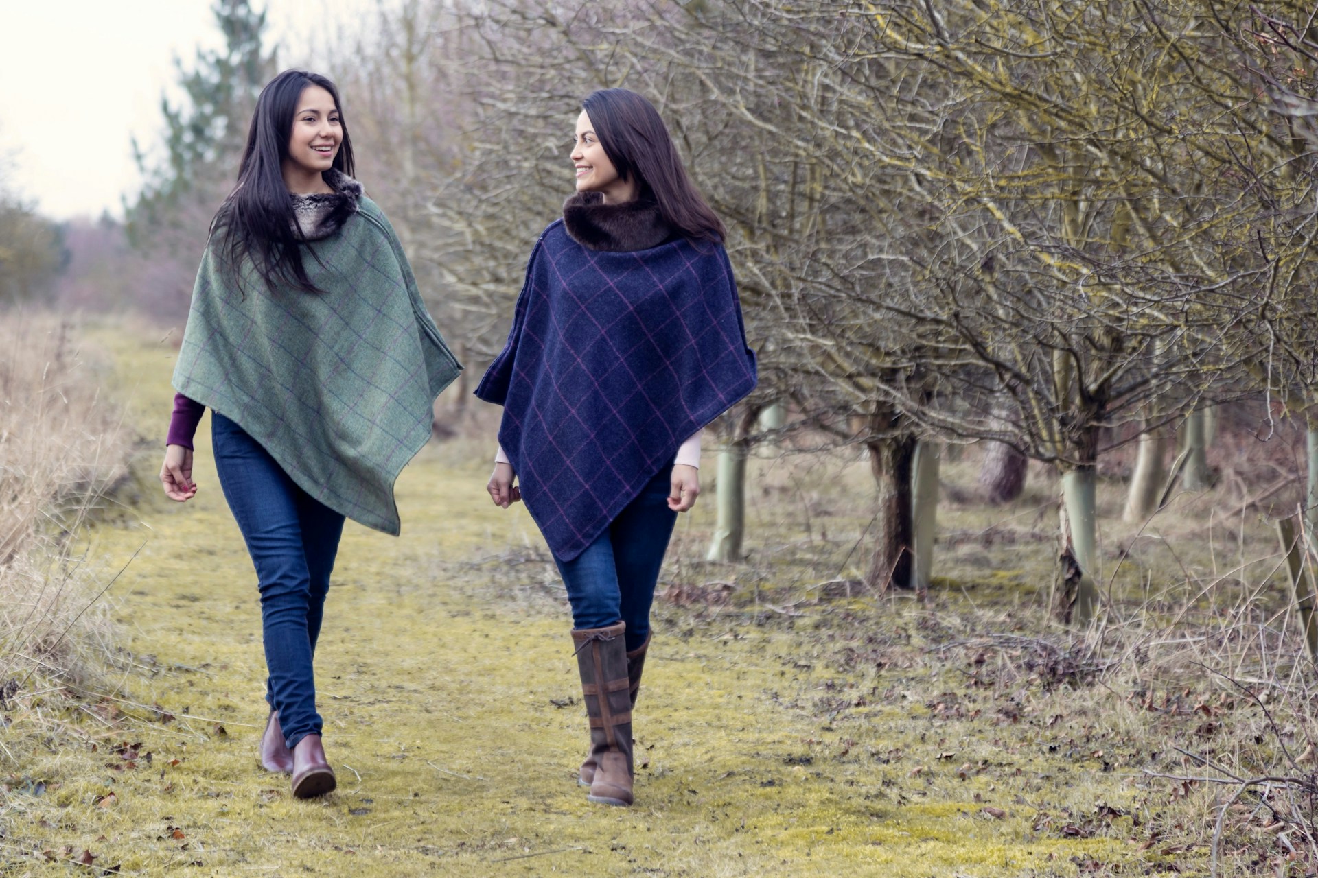 Two women walking down a path holding hands