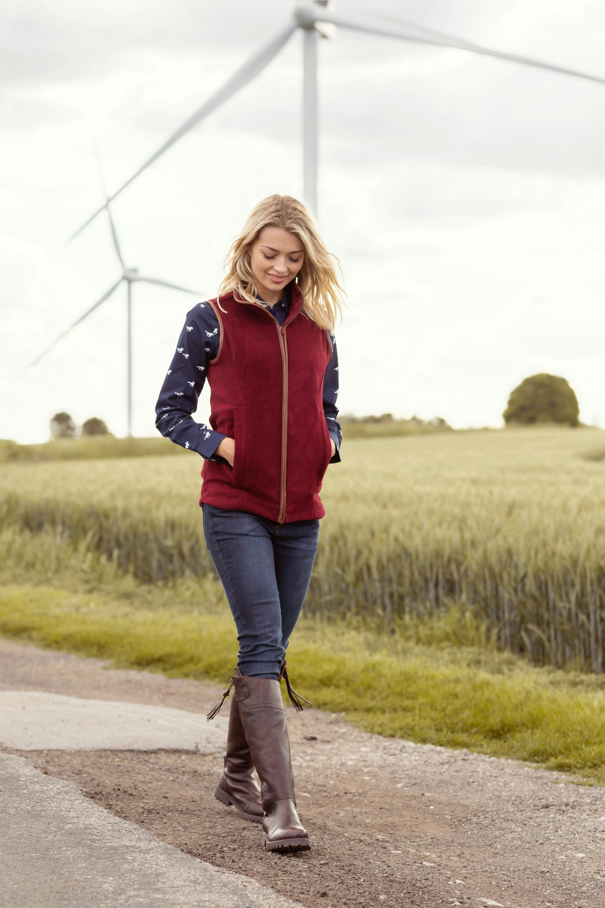 Une femme marchant sur une route à côté d’une éolienne