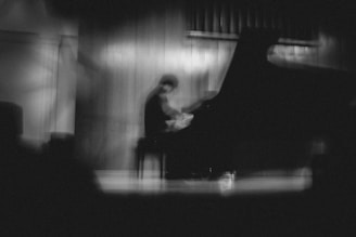 A black and white photo of a person playing a piano