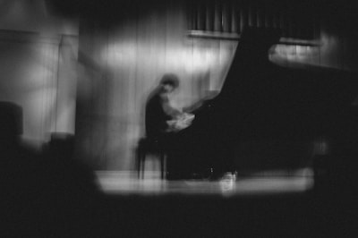 A black and white photo of a person playing a piano