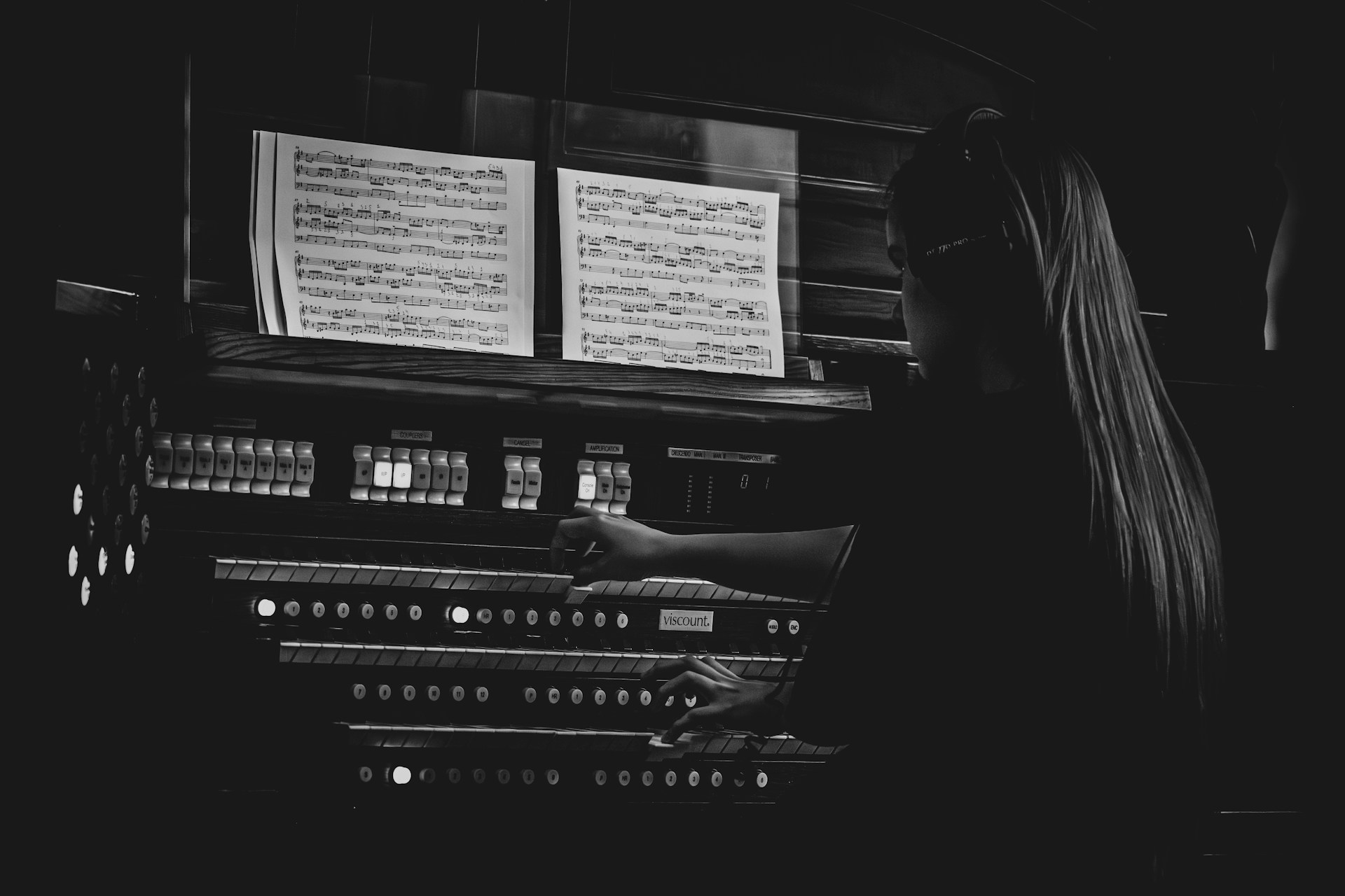 A woman standing in front of a pipe organ