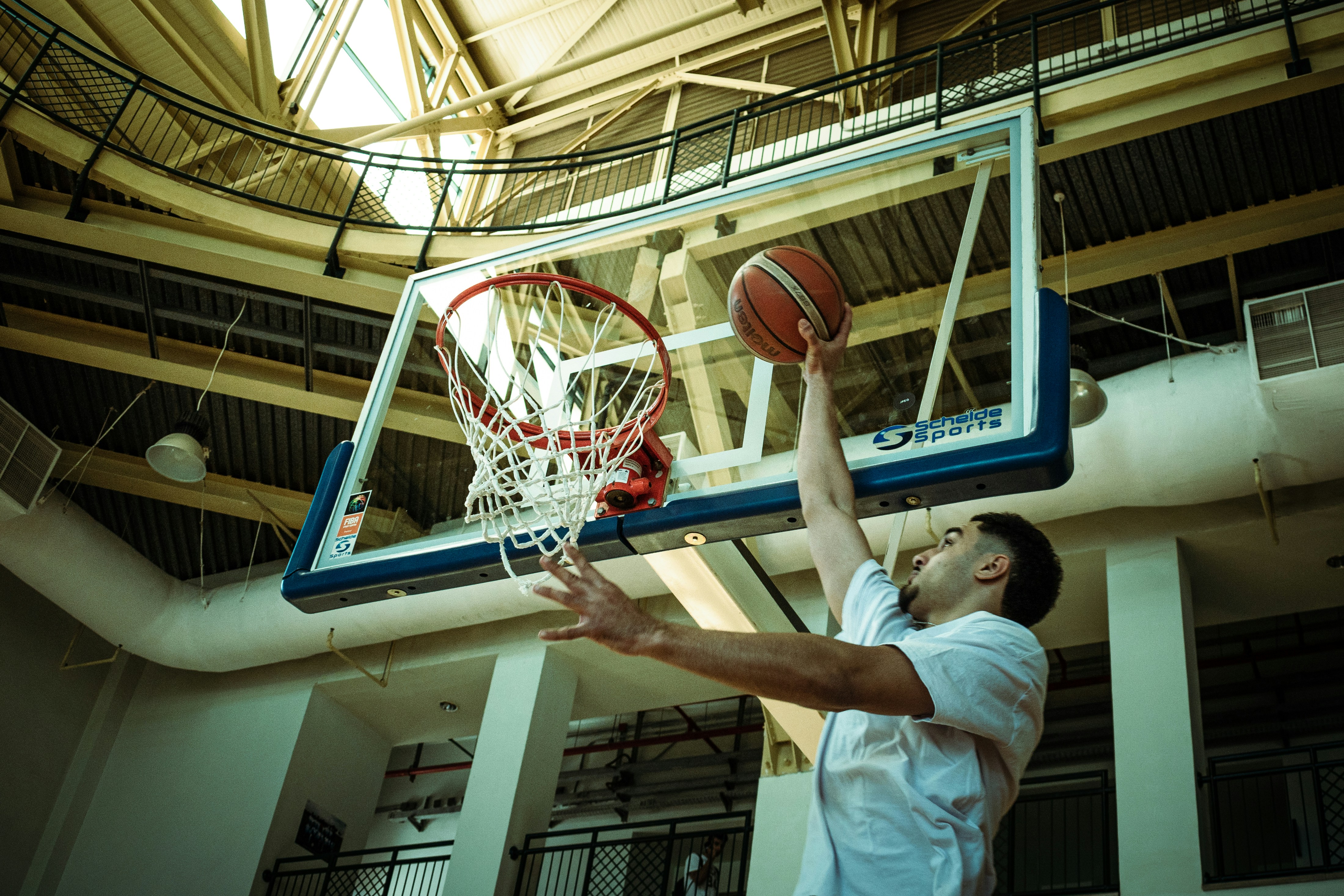 A man dunking a basketball in a gym