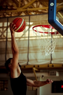 A woman dunking a basketball into a hoop