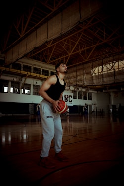 A man standing in a gym holding a basketball
