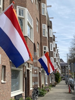 A row of brick buildings with flags hanging from the windows