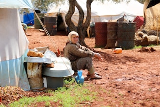 A woman sitting on a toilet outside of a tent