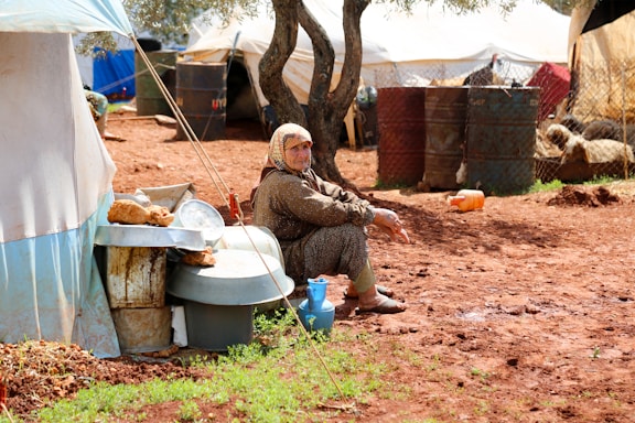 A woman sitting on a toilet outside of a tent
